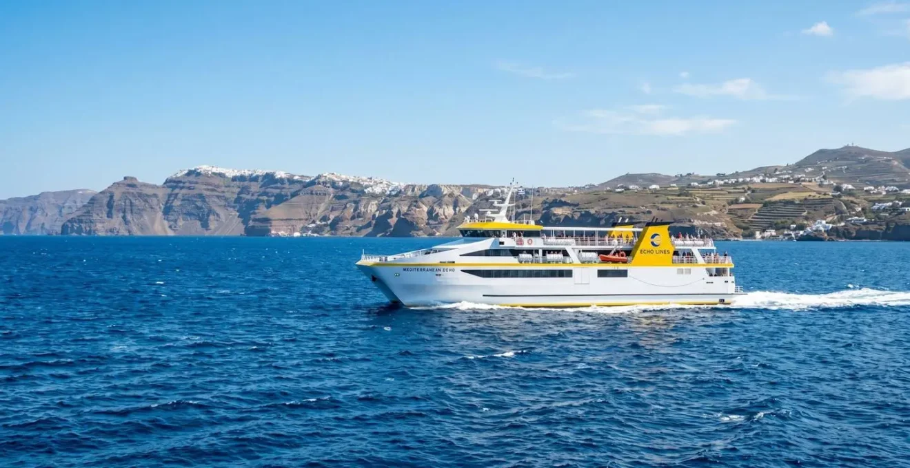 Ein modernes weiß-gelbes Fährschiff von Corsica Ferries fährt bei strahlendem Sonnenschein über das tiefblaue Mittelmeer mit Küstenlandschaft im Hintergrund